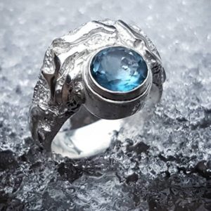 Bague avec motifs et topaze bleue